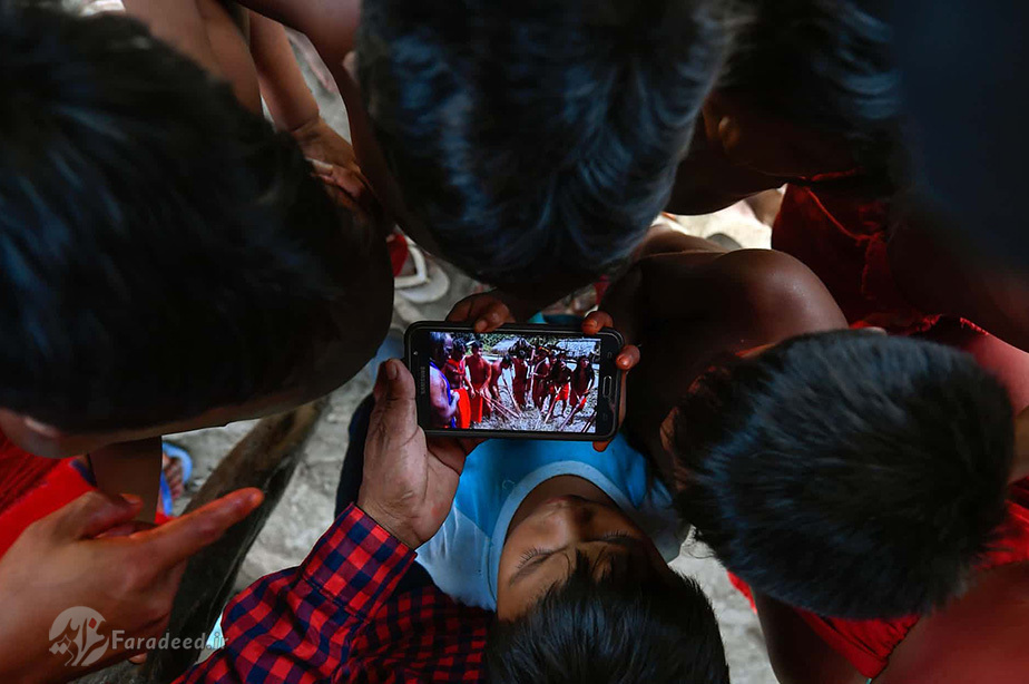 کودکان بومی در حال تماشای یک ویدیو از رقص قبیله‌ای سنتی در آماپا، برزیل