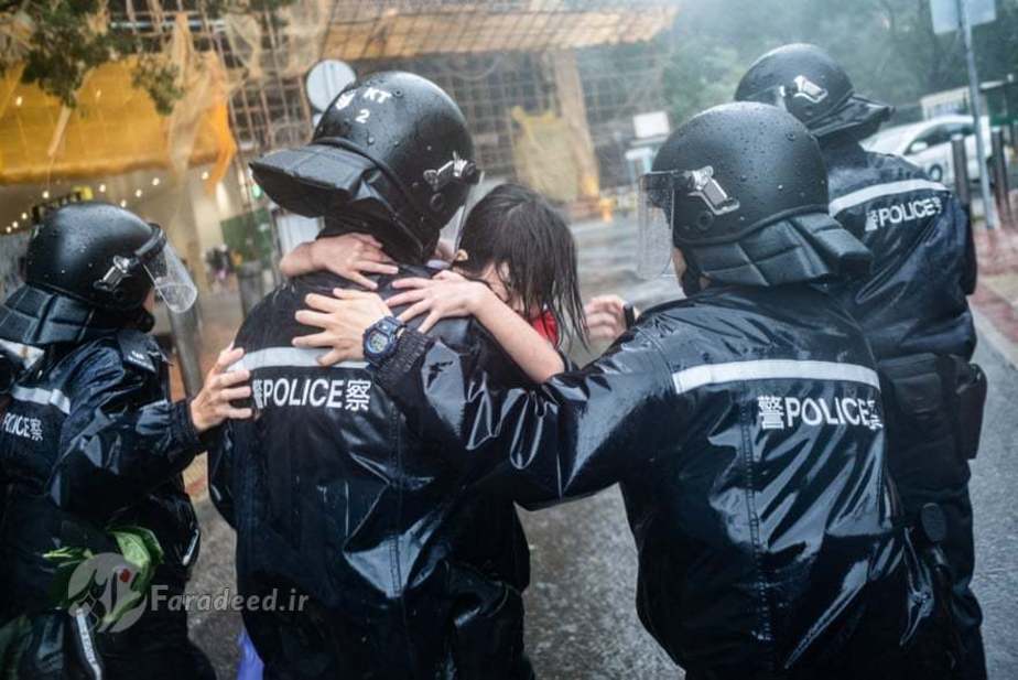 مأموران پلیس کودکان را از مدرسهای که بر اثر طوفان در هنگ کنگ ویران شده بیرون میآورند