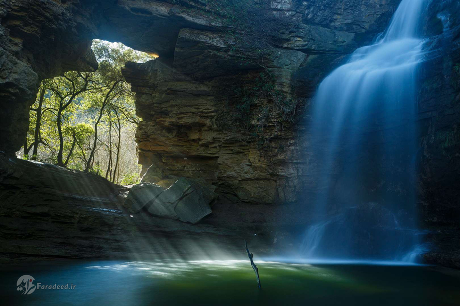 آبشار کاتالونیا اسپانیا و تابش خورشید از روزنههای کوه