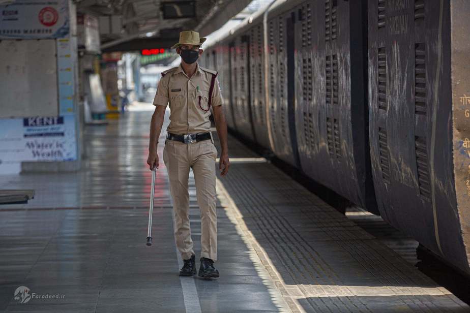 افسر امنیت در ایستگاهِ قطارِ خالی قدم میزند. عکاس: Anupam Nath/AP