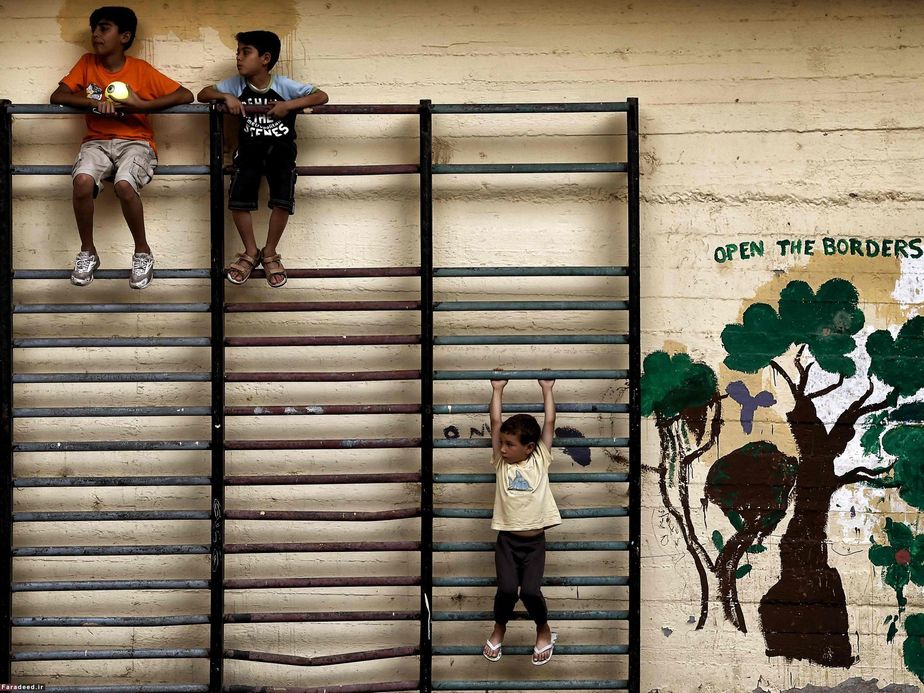 کودکان در حیاط مدرسه‌ای در آتن که پناهگاه پناهندگان سوری و افغان شده است