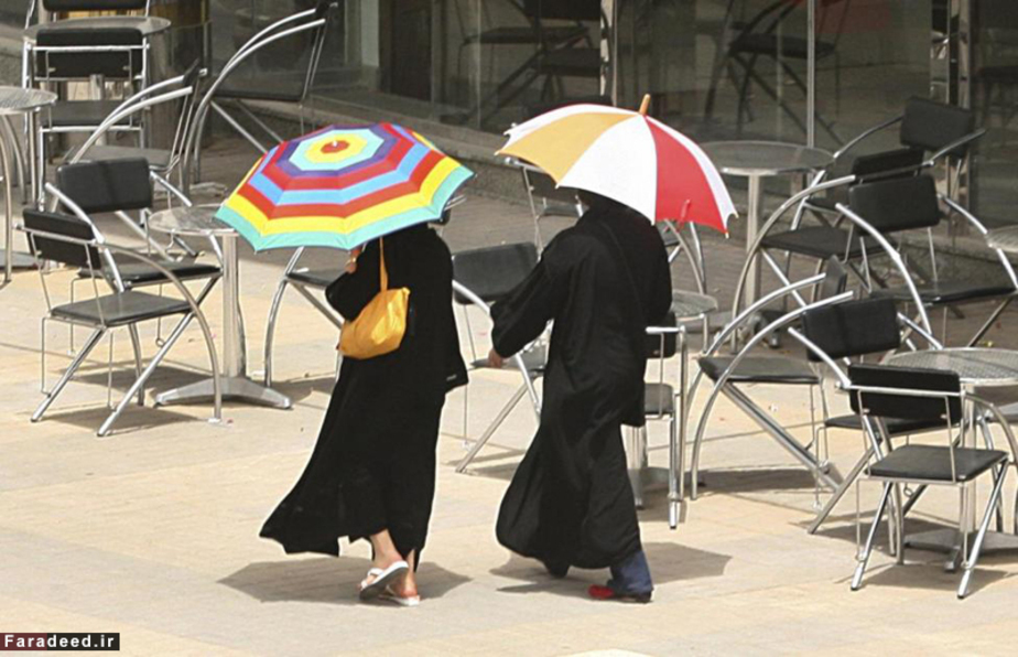 دو زن در حال عبور از کنار یک کافی شاپ در ریاض